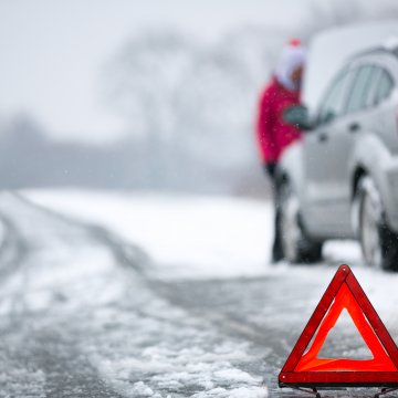 assurant vehicle service contracts extended car warranty car breakdown in winter car at the side of the road snow on the road red triangle in the foreground